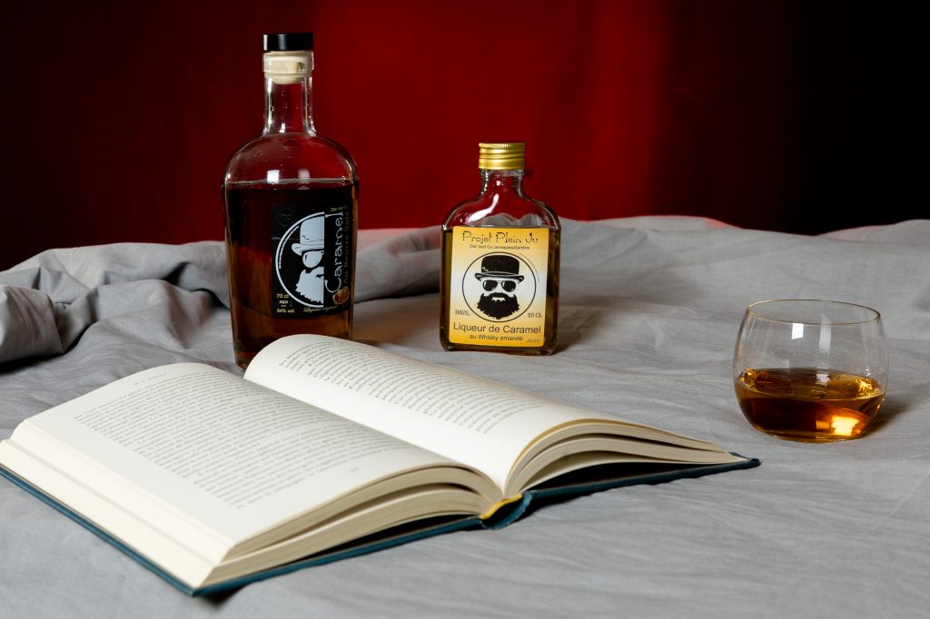 Mise en valeurs de produit deux bouteille de rhum, un livre ouvert fond rouge