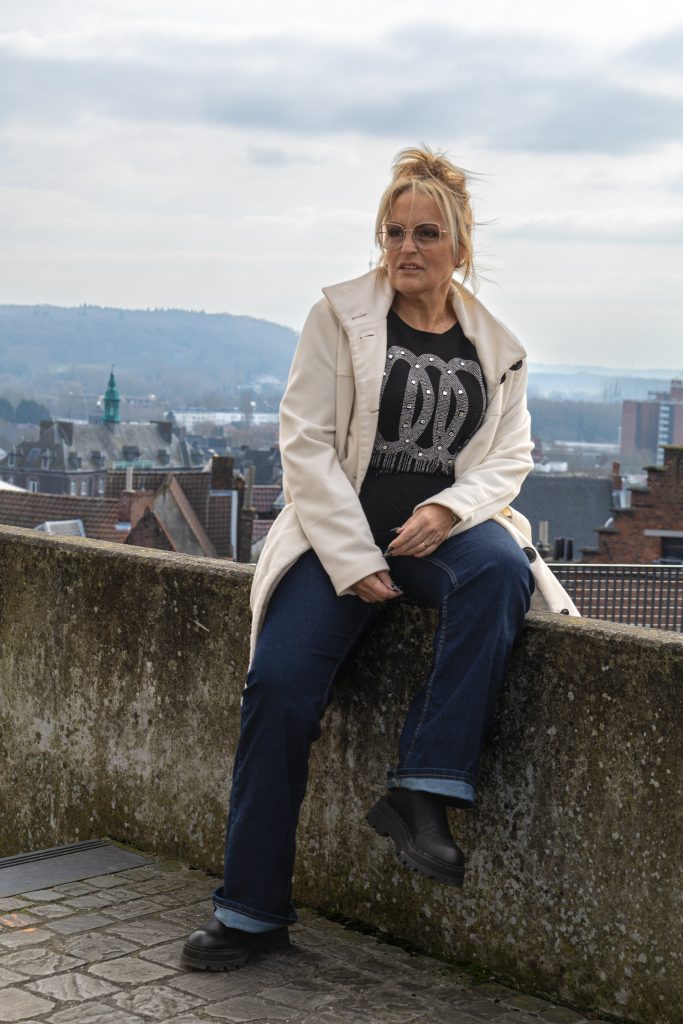 Portrait féminin sur un rempart, arrière-plan nuageux.