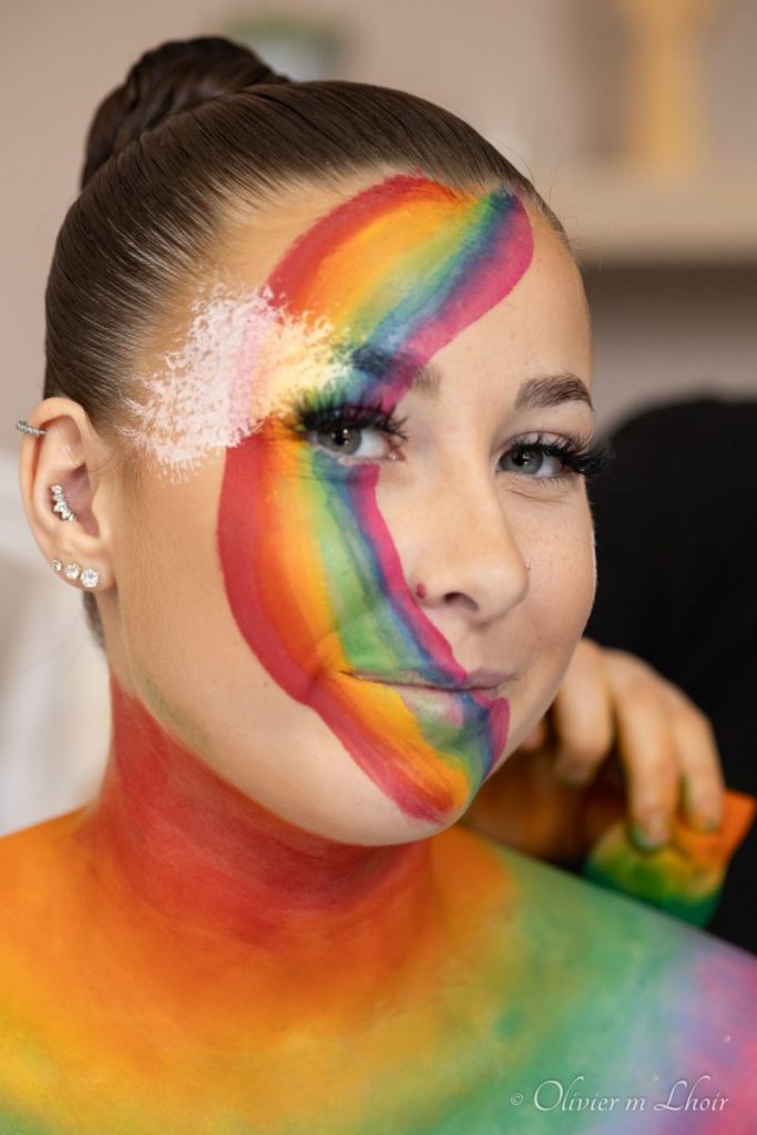 Portrait de jeune femme grimée en arc en ciel