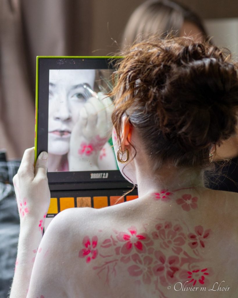 reflet dans un miroir, d'une jeune femme se grimant
