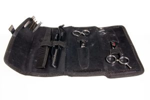 trousse de coiffure avec peigne ciseaux rasoir en cuir noir sur fond blanc