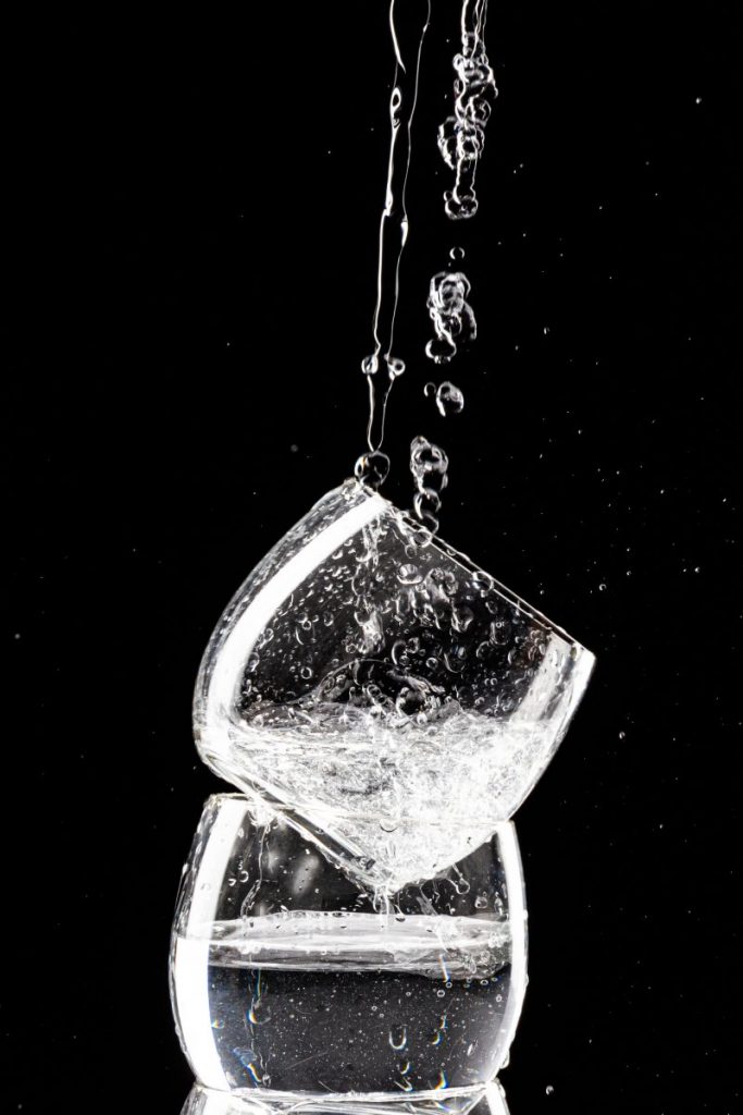 deux verre superposé avec un filet d'eau qui coule dessus