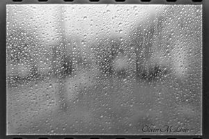 goutte de pluie en argentique noir et blanc au travers d'une vitre